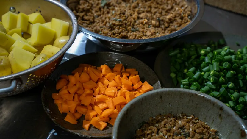 Bowls of separately prepped potatoes, carrots, green beans and mince.