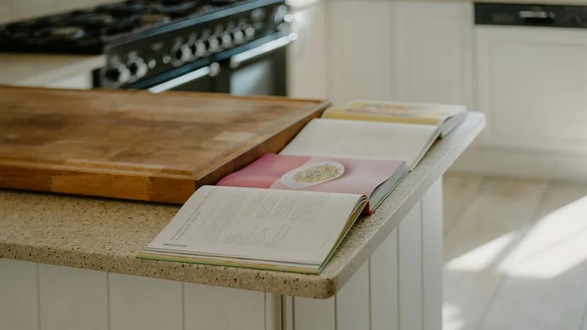 Two open cookbooks side by side on a kitchen counter.