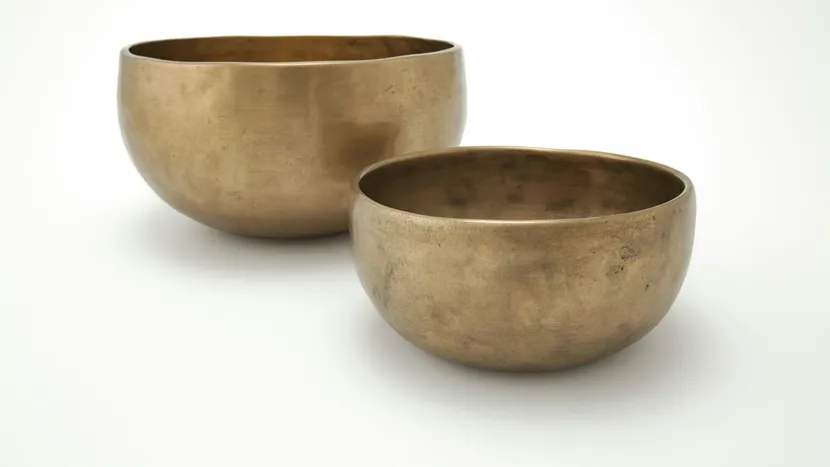 Two brass bowls of different sizes side by side.