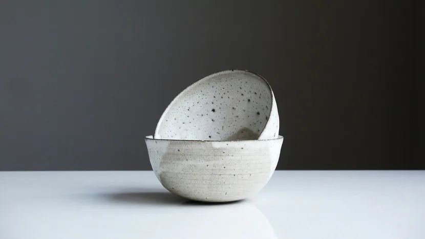 Two speckled ceramic bowls, one resting inside the other.