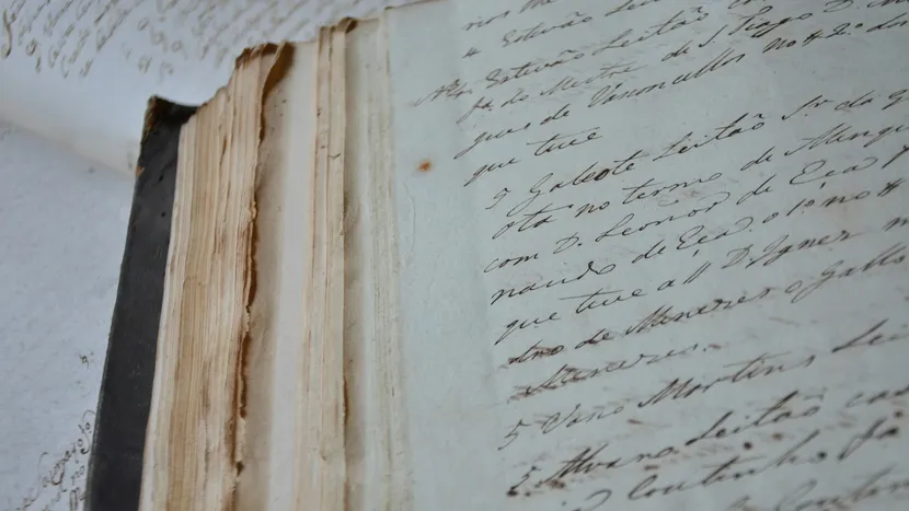 A worn notebook open to pages of faded handwriting.